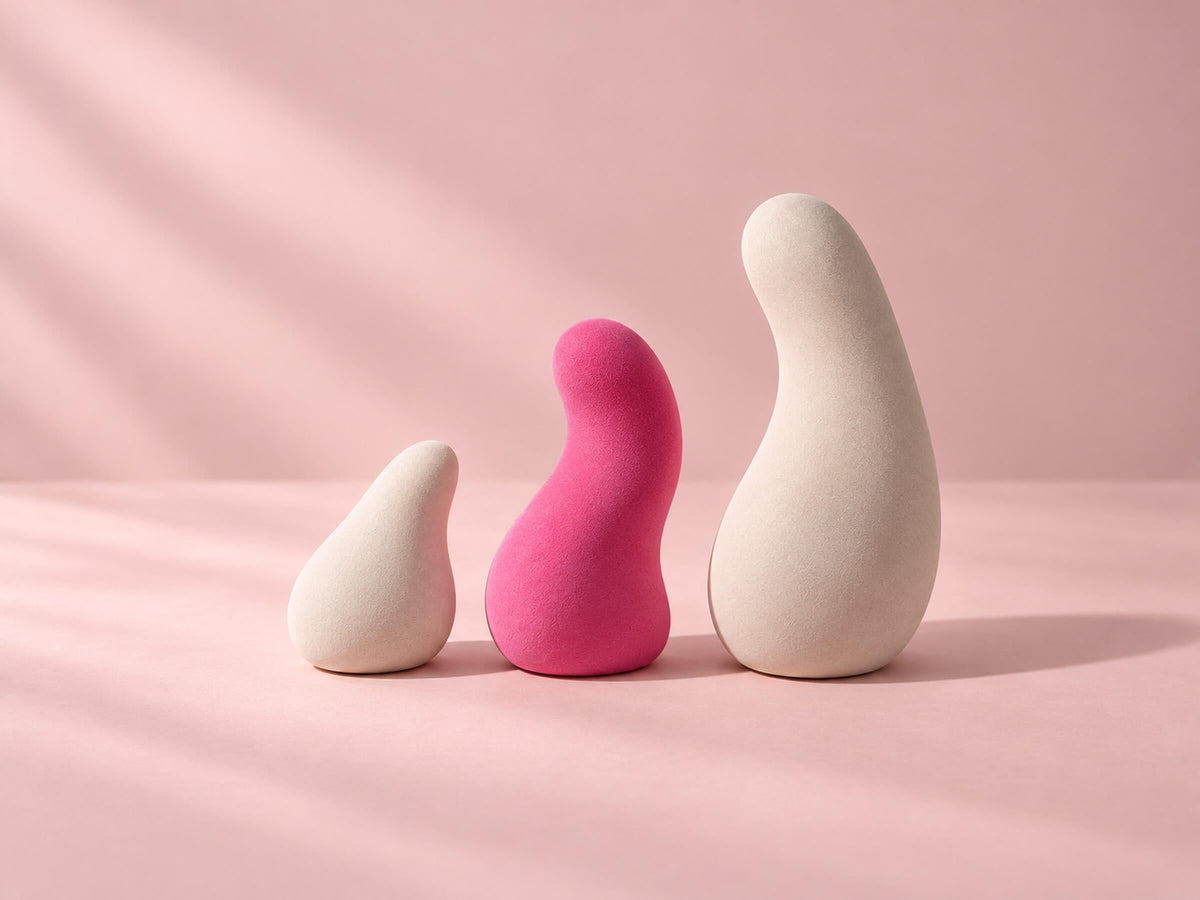 Trois objets de tailles différentes alignés sur un fond pastel, pour choisir son vibromasseur