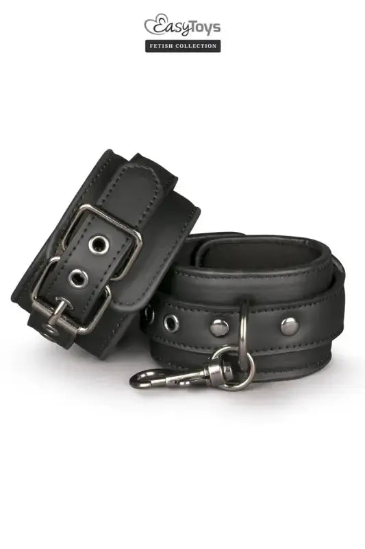 Menottes de bondage Easytoys Fetish Collection en cuir noir avec boucle et rivets.