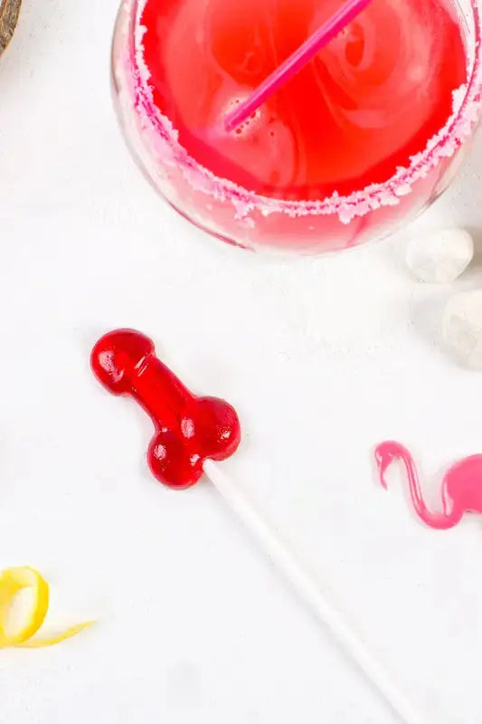 Sucette pénis alcoolisée goût daiquiri fraise avec un cocktail coloré pour des soirées amusantes.