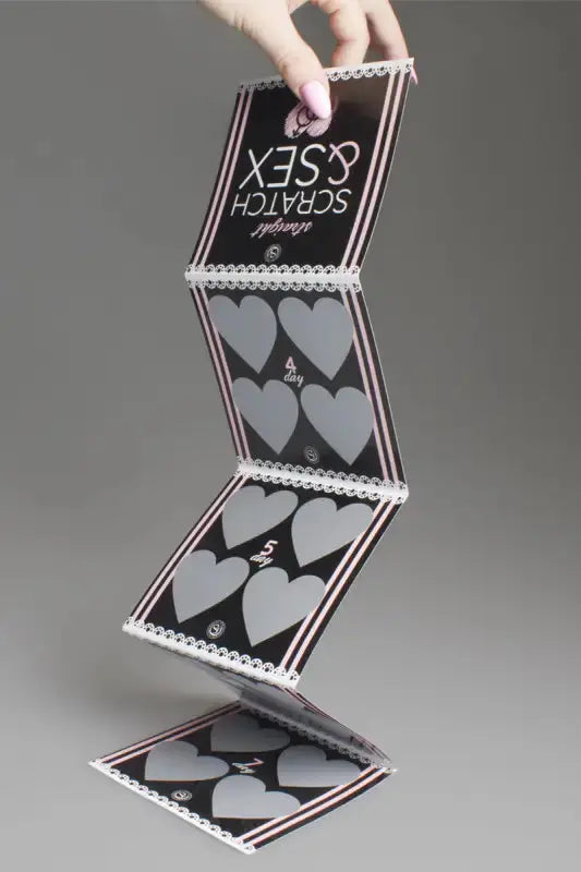 Jeu coquin Carte à gratter pliée avec des zones de grattage en forme de cœur.