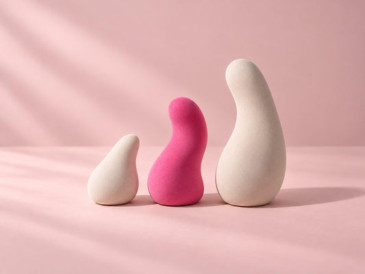 Trois objets de tailles différentes alignés sur un fond pastel, pour choisir son vibromasseur