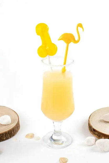 Sucette pénis alcoolisée goût pina colada dans un verre avec décorations amusantes.