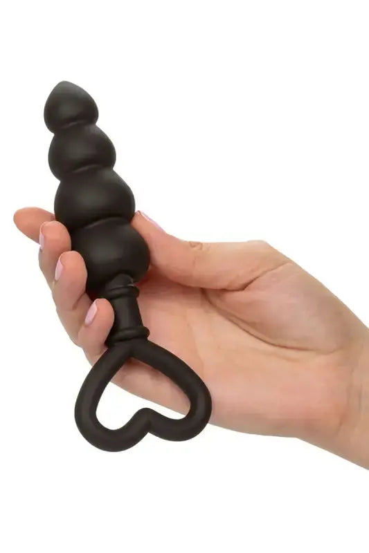 Bouchon  plug anal en perles noires avec poignée en forme de cœur.