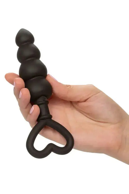 Bouchon  plug anal en perles noires avec poignée en forme de cœur.