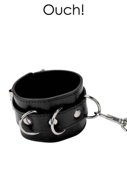 Menottes cuir Ouch! en cuir noir avec anneaux métalliques, parfaites pour les jeux BDSM.